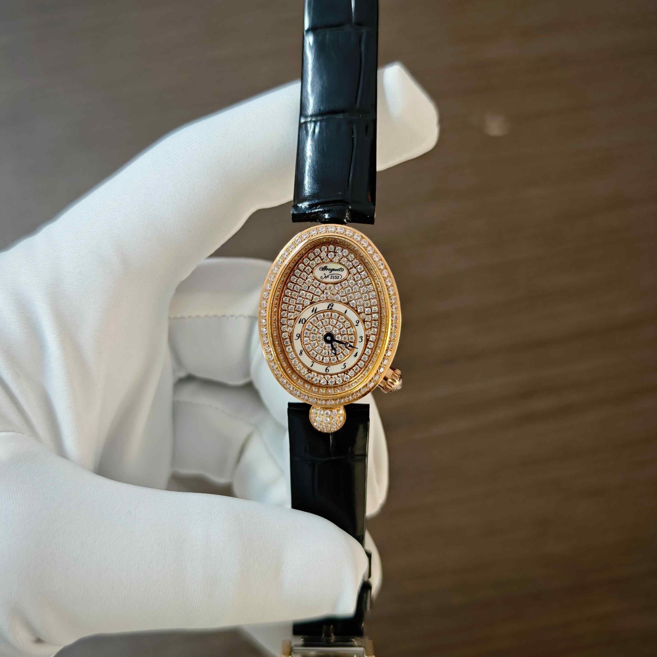 Breguet Reine de Naples rose gold luxury watch featuring a full diamond-set case and elegant diamond dial with an oval design.