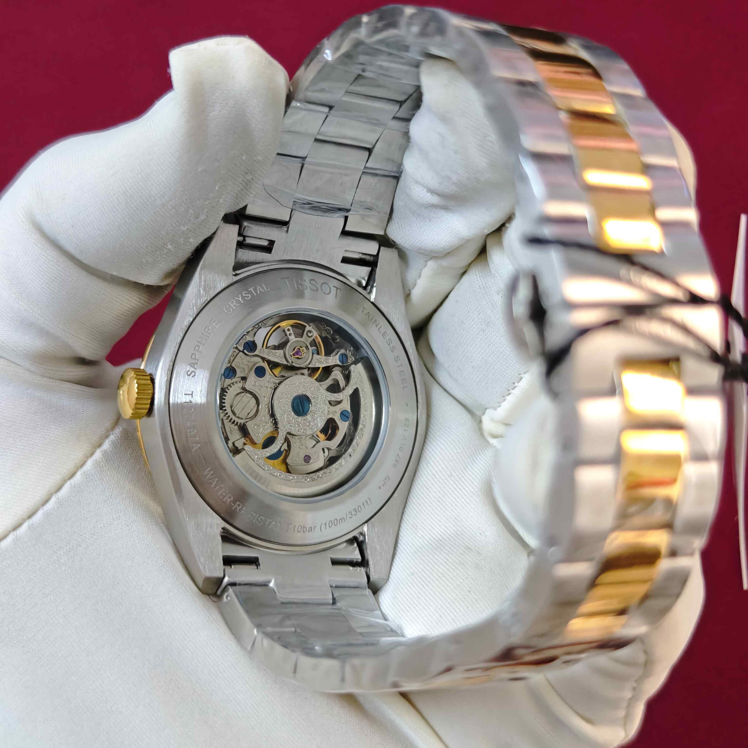 Tissot Gentleman Powermatic 80 Open Heart automatic watch featuring a black dial, gold dual-tone stainless steel bracelet, elegant gold accents, and visible mechanical movement.